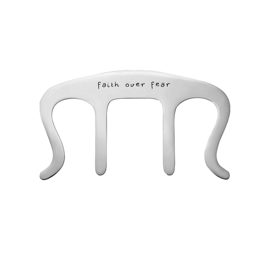 White music book holder clip with 'faith over fear' message, isolated on a white background.