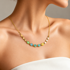 Personalized name necklace with colorful enamel letters and gold heart beads worn on neck