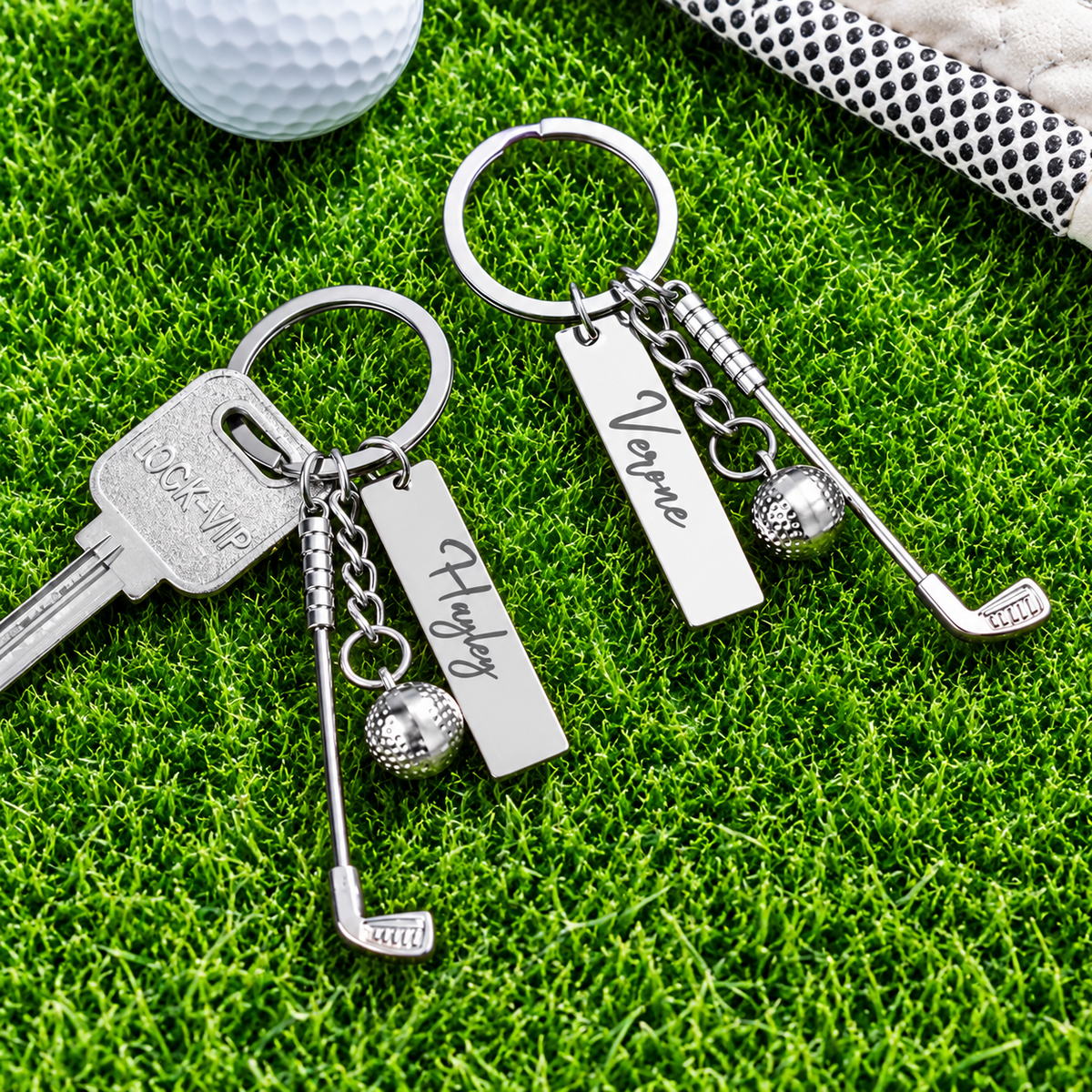 Two personalized golf keychains with custom name tags, golf club charms and golf ball accents on grass