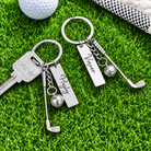 Two personalized golf keychains with custom name tags, golf club charms and golf ball accents on grass