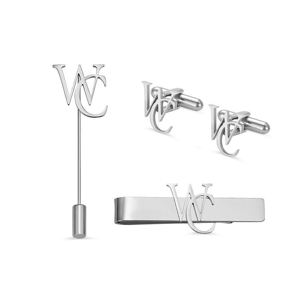 Silver lapel pin, cufflinks, and tie bar set with intertwined initials WC on a white background.