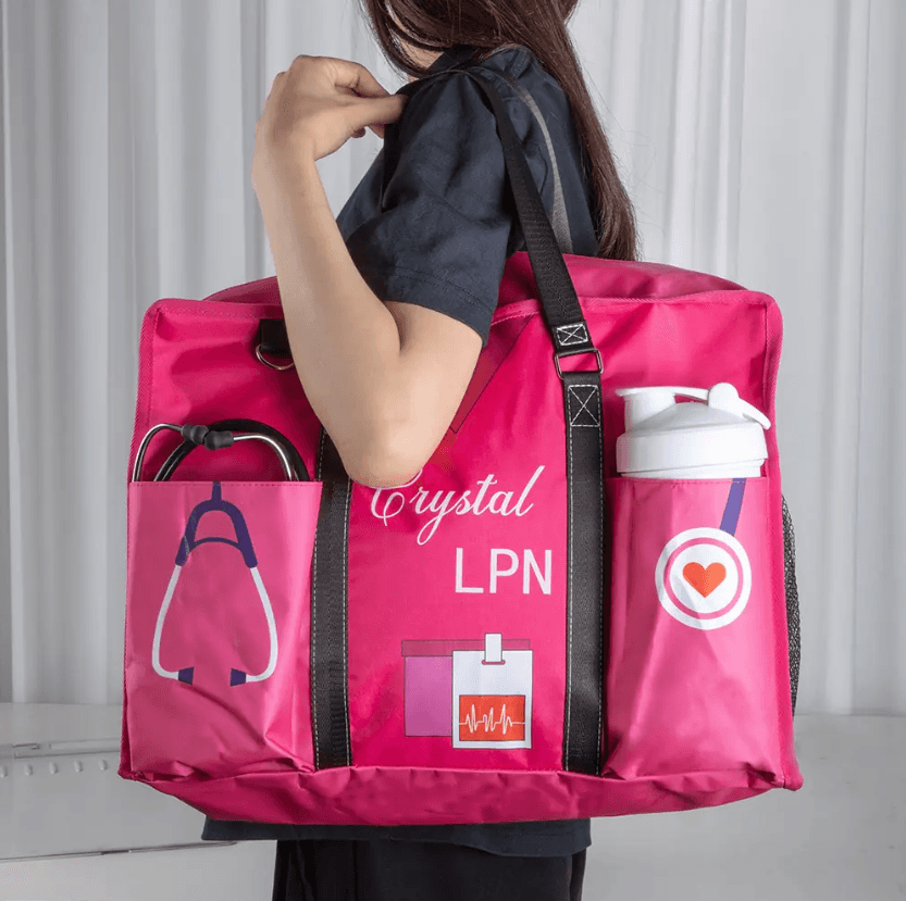 Nurse in uniform carrying a personalized pink nurse tote bag labeled 'Crystal LPN' with multiple pockets and stethoscope.