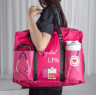 Nurse in uniform carrying a personalized pink nurse tote bag labeled 'Crystal LPN' with multiple pockets and stethoscope.