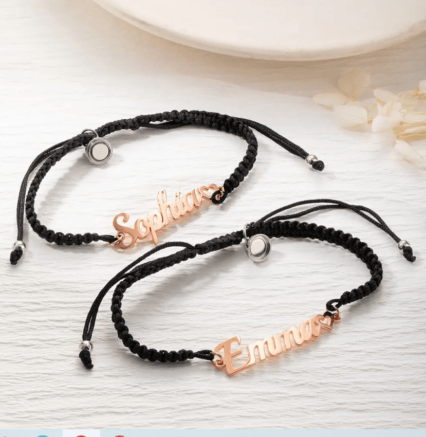 Two black cord bracelets with rose gold nameplates, one reading "Sophia" and the other "Emma," both featuring a small heart at the end of the name.