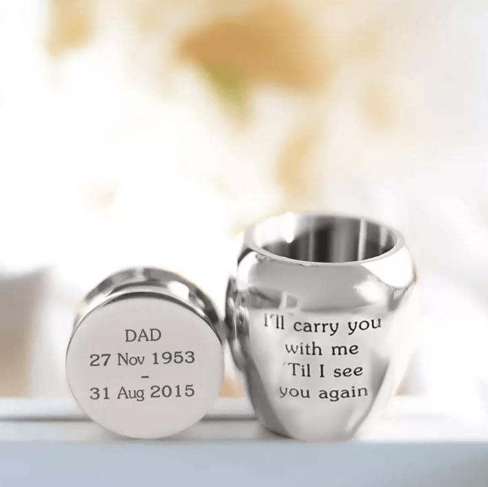 Personalized urn with 'DAD' and dates, beside 'I'll carry you with me 'Til I see you again'.