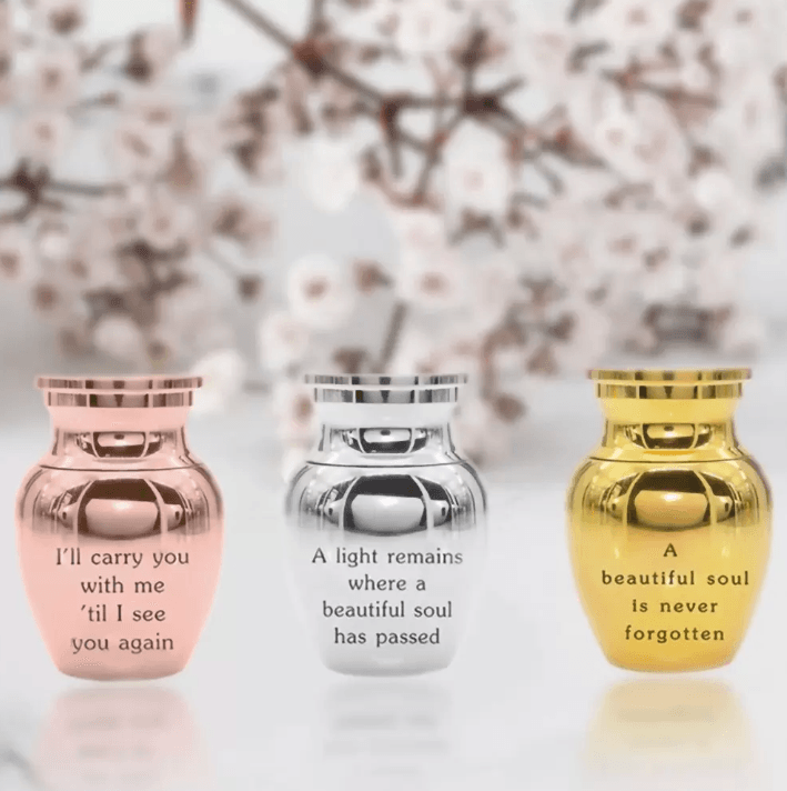 Rose gold, silver, and gold urns with inspirational quotes, against a floral backdrop.