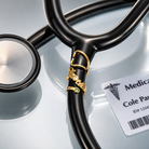 Gold personalized birthstone stethoscope name tag attached to black stethoscope