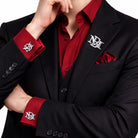 Silver interlocking initials cufflinks and matching lapel pin set worn with a black suit and burgundy shirt