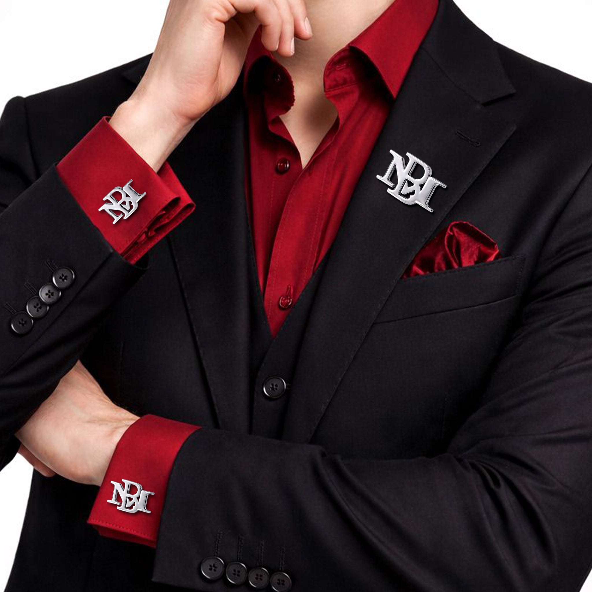 Silver interlocking initials cufflinks and matching lapel pin set worn with a black suit and burgundy shirt