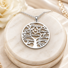 Silver personalized family tree necklace with custom names on a cream stand