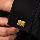 Engraved gold cufflink worn with black formal shirt