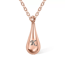 Rose gold teardrop pendant necklace with the letter "K" on a white background