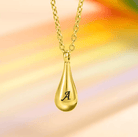 Gold teardrop pendant with letter "A" on a rainbow-colored background