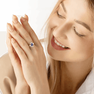 Smiling woman wearing an Exquisite Blue Star Sapphire and Pearl Ring with Sterling Silver and 18K Gold Plating, showcasing unique custom-designed jewelry.