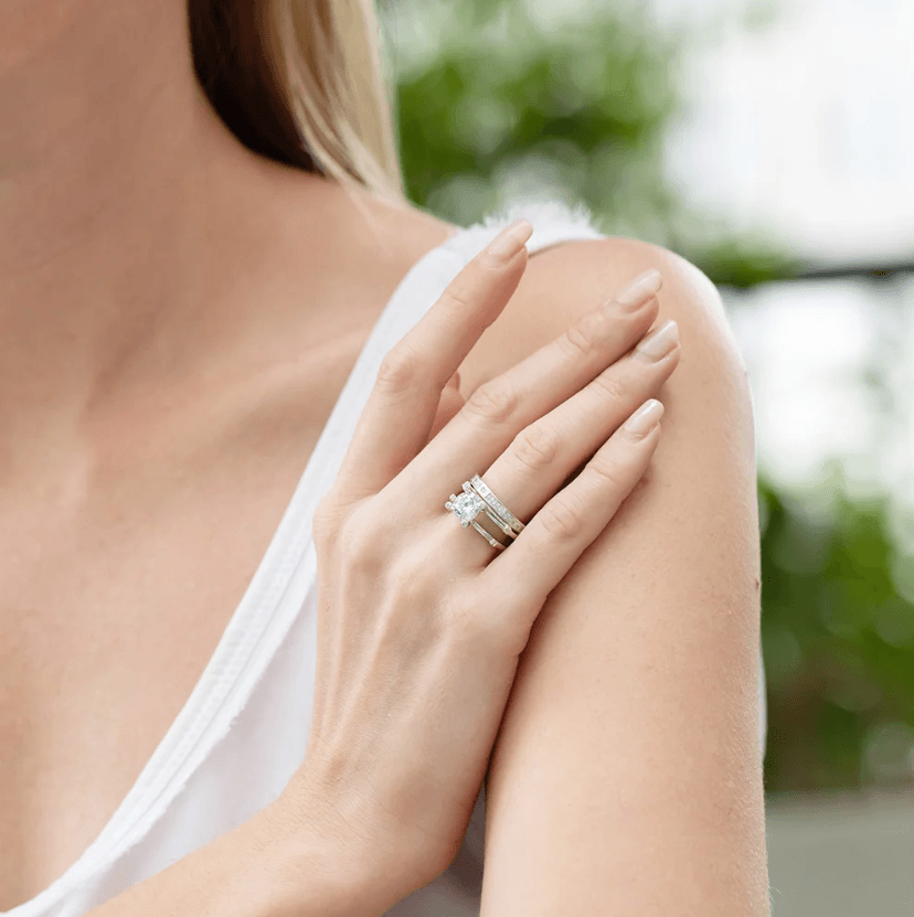 Woman wearing a stackable triple-band diamond ring set with a custom clear birthstone, crafted in premium Sterling Silver 925, featuring elegant silver bands.