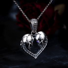 Silver necklace with a heart-shaped skull pendant and purple gem against a dark floral backdrop.