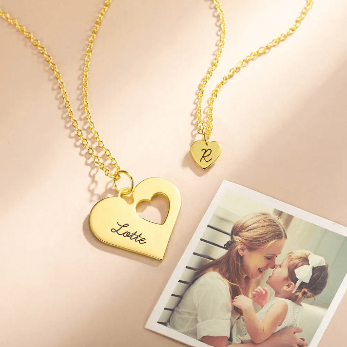 Layered gold mother-daughter heart necklace set with engravings 'Lotte' and 'R', placed beside a photo of a mother and child, symbolizing their special bond.