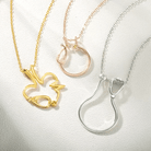 Gold, rose gold, and silver ring holder necklaces with heart, stethoscope, and EKG designs. Each pendant features a customizable birthstone, ideal for medical professionals.