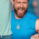 Cheerful man in a blue tank top wearing a silver basketball pendant engraved with 'Aiden' and number '13