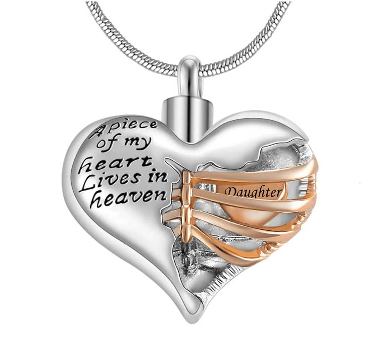 A heart-shaped pendant with the inscription "A piece of my heart lives in heaven," featuring a gold ribbon with the word "Daughter."