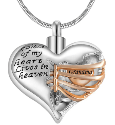 A heart-shaped pendant with the inscription "A piece of my heart lives in heaven," featuring a gold ribbon with the word "Grandma."