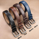 Assorted leather belts in black, tan, brown, and navy, each with a sleek metal buckle, displayed in an overlapping arrangement.