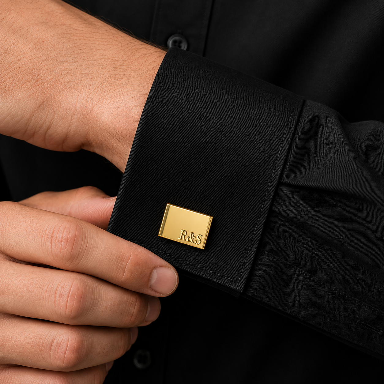 Gold engraved rectangle cufflink worn with black dress shirt