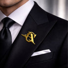 Personalized gold overlapping initials lapel pin worn on a black suit