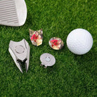 Custom golf divot tools and personalized photo ball markers displayed on grass with golf ball
