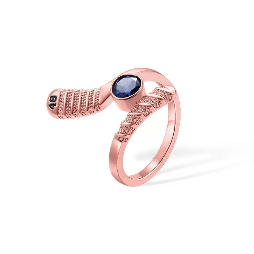 Rose gold-toned hockey stick-shaped ring with a deep blue gemstone and '88' number detail, a stylish gift for sports enthusiasts.