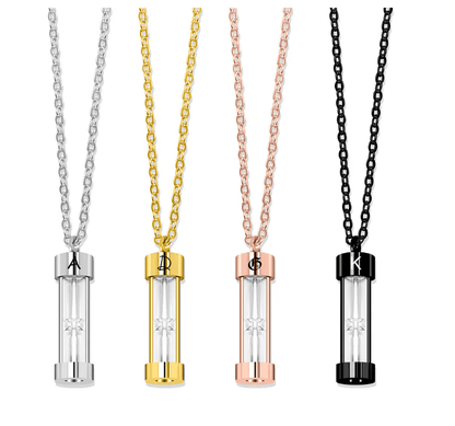 Collection of hourglass urn necklaces in silver, gold, rose gold, and black, each personalized with a unique initial.