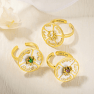 Three gold spinner rings with engraved names and colorful birthstones, perfect for personalized decision-making and unique, customizable gifts.