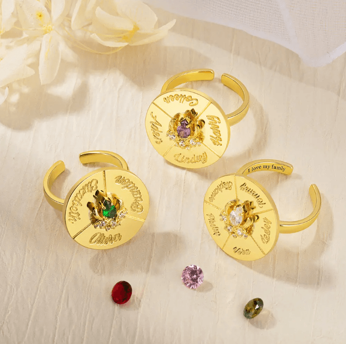 Three gold spinner rings with engraved names and colorful birthstones, perfect for personalized decision-making and as unique, customizable gifts.