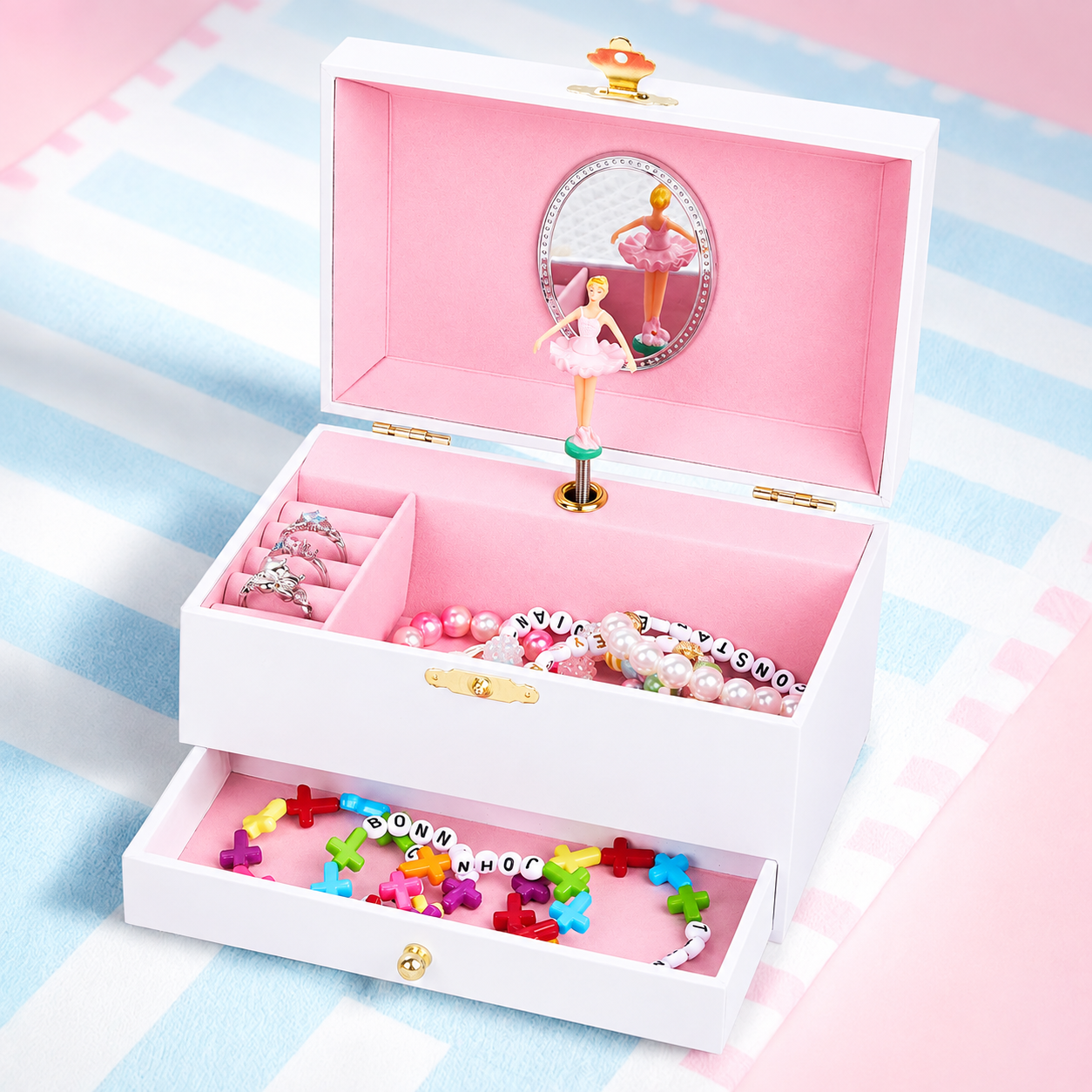 Pink personalized musical ballerina jewelry box open with colorful jewelry and storage drawer