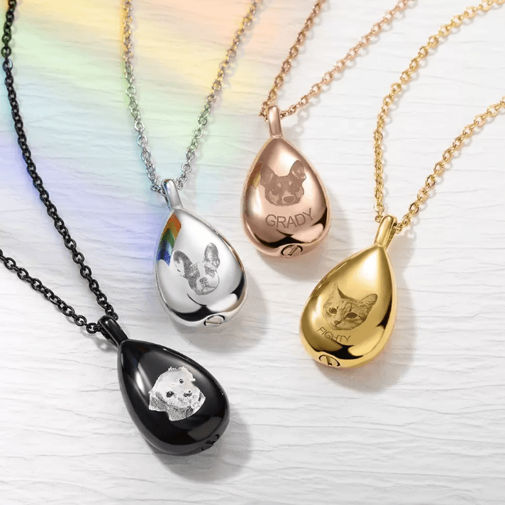 Collection of teardrop pendants in black, stainless steel, rose gold, and gold, each engraved with pet images