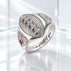 Personalized silver football ring with red birthstone, engraved name Kevin, and “I am proud of you” message on a white glass background.