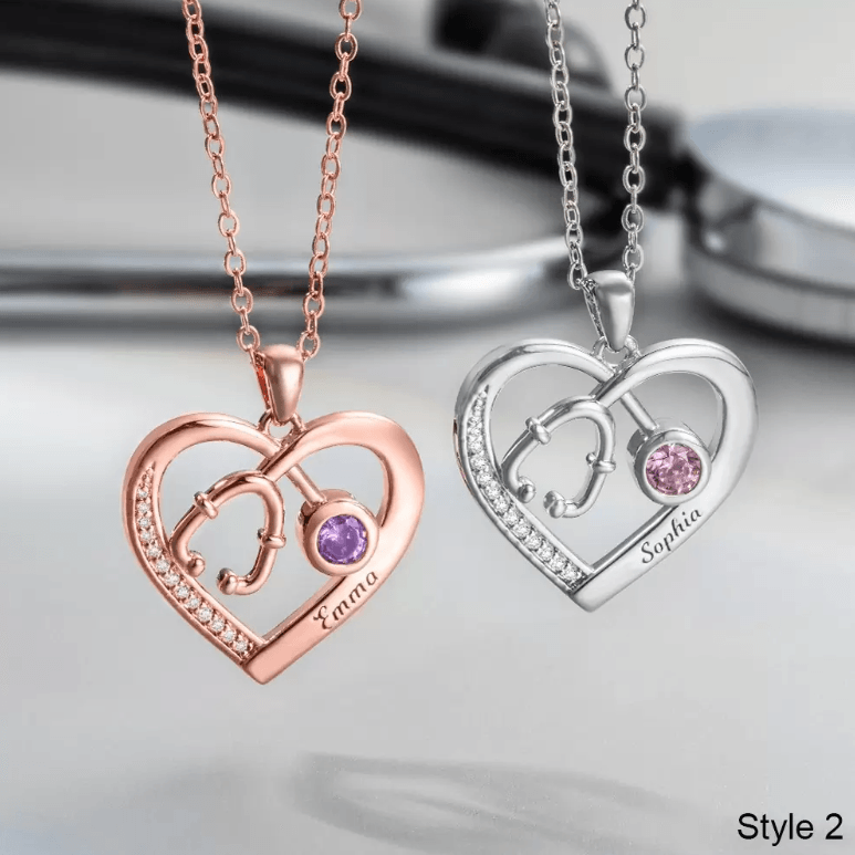 Two personalized heart-shaped necklaces with stethoscope designs and birthstones: 'Emma' in rose gold and 'Sophia' in silver.