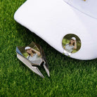 Personalized golf ball marker attached to white golf cap with custom photo divot tool