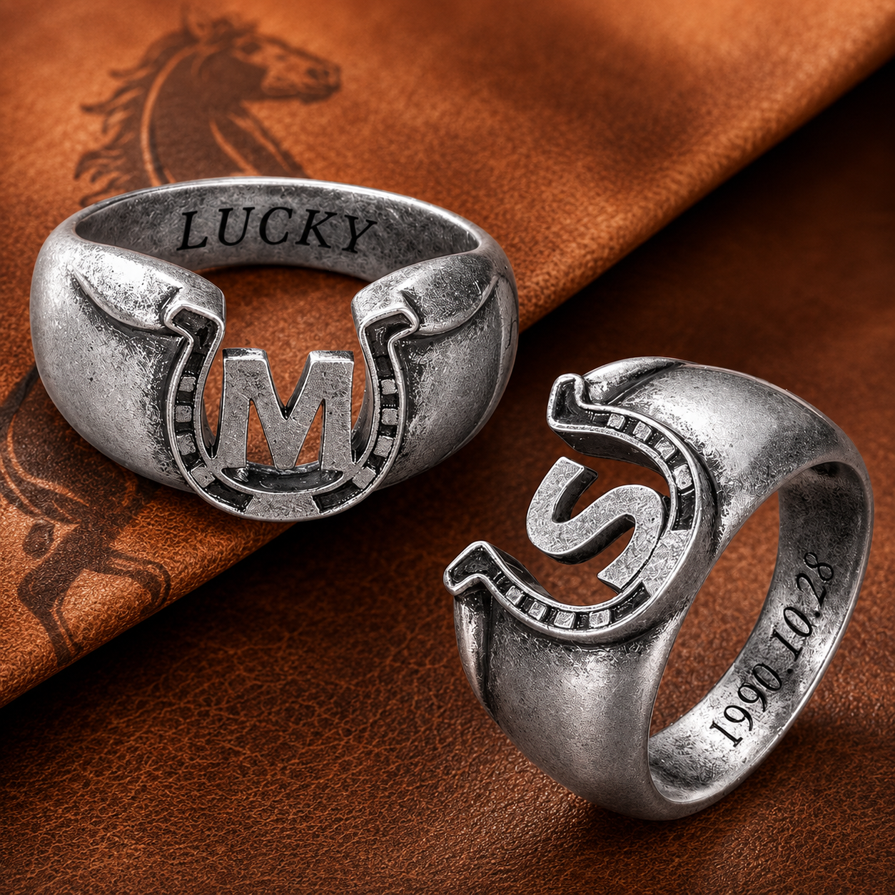Custom initial horseshoe rings with M and S letters displayed on brown leather