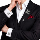 Silver interlocking initials cufflinks and lapel pin set worn with a black suit and white shirt