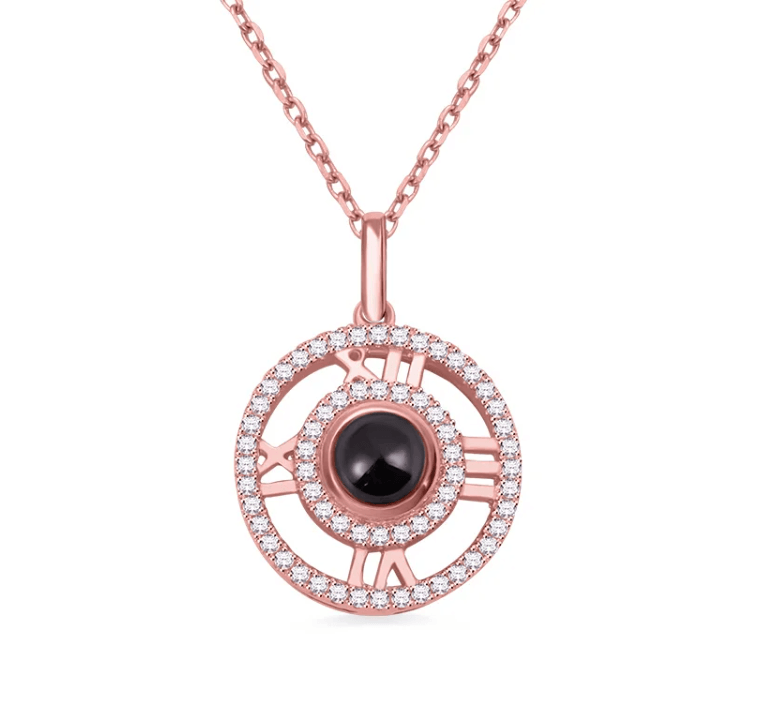 Rose gold pendant with a circular design featuring Roman numerals, a black central gemstone, and sparkling diamonds on a fine chain.