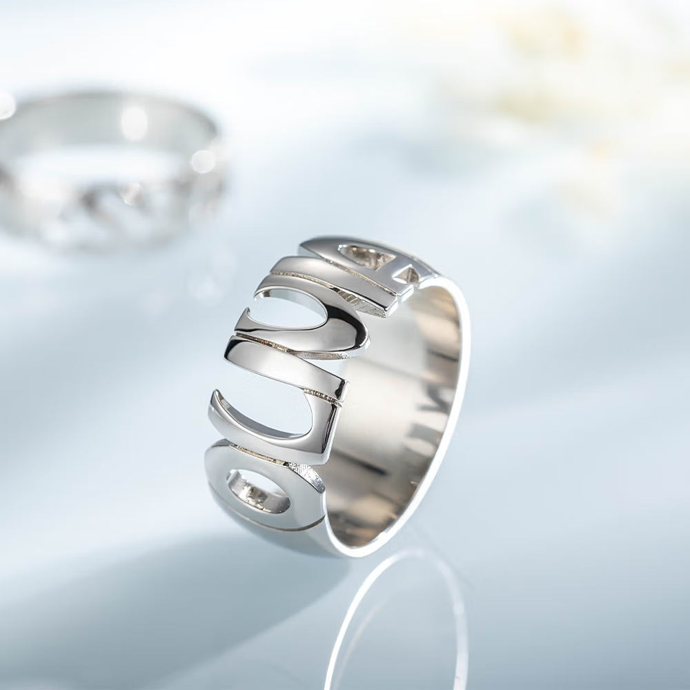 Close up of custom name ring in 925 sterling silver held between fingers