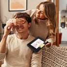 Couple presenting a personalized long distance map gift in a black frame