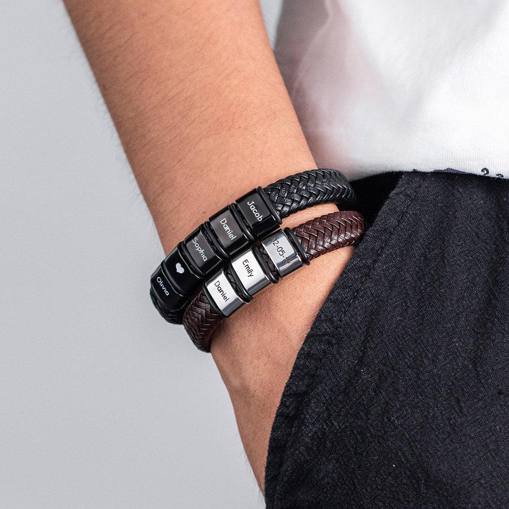 Person wearing two personalized leather bracelets with engraved stainless steel beads.