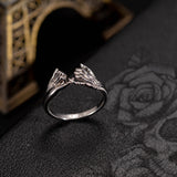 Elegant silver pinky promise ring displayed on a dark backdrop with rose design and the Eiffel Tower.