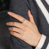 Silver Skeleton Hand Pinky Promise Ring on Middle Finger Over Grey Sweater
