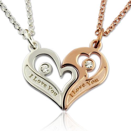 A pair of complementary heart-shaped pendants, one in silver and one in rose gold, each with a gemstone and "I Love You" inscription, attached to matching chains.