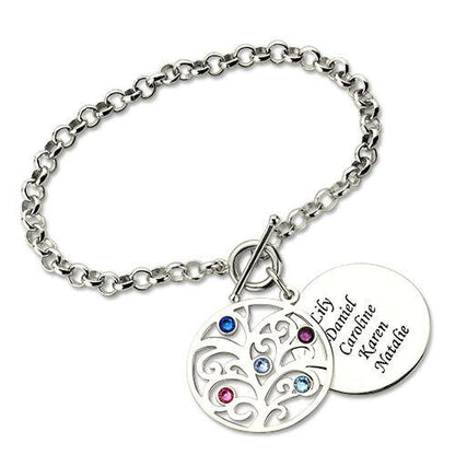 A silver charm bracelet with a tree pendant featuring colored gemstones and a round disc engraved with the names Lily, Daniel, Caroline, Karen, and Natalie.