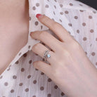 Hand wearing a silver angel wing ring with blue stone, matching a polka dot blouse BD37-4 - 600 x 600px