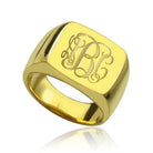 A square gold signet ring with a polished finish, featuring the 1864 Gilles Le Corre monogram style engraved on the face, displaying the initials "ABC" in an elegant script.